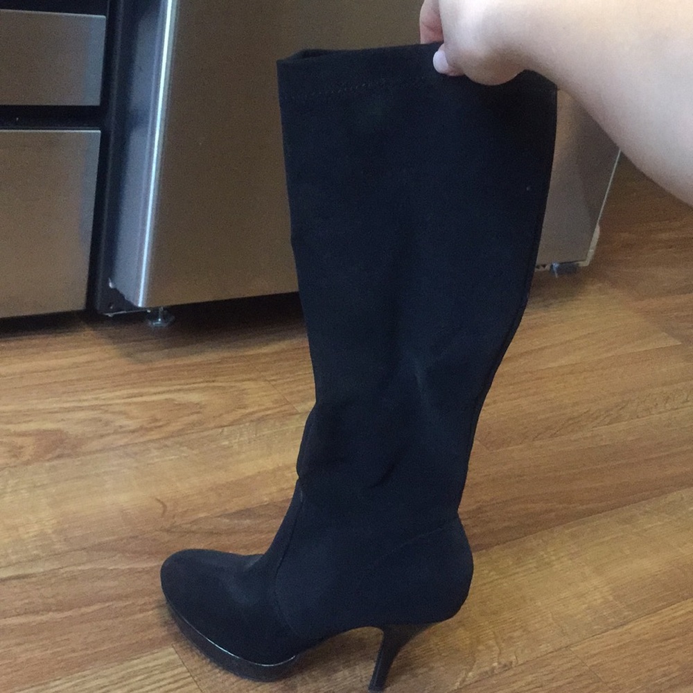 Black knee high heeled boots.
